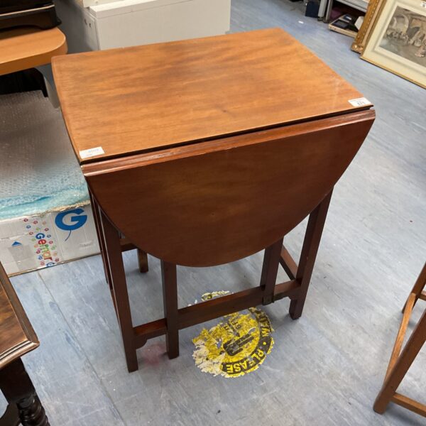 Antique mahogany gate leg table with hinged leaves.