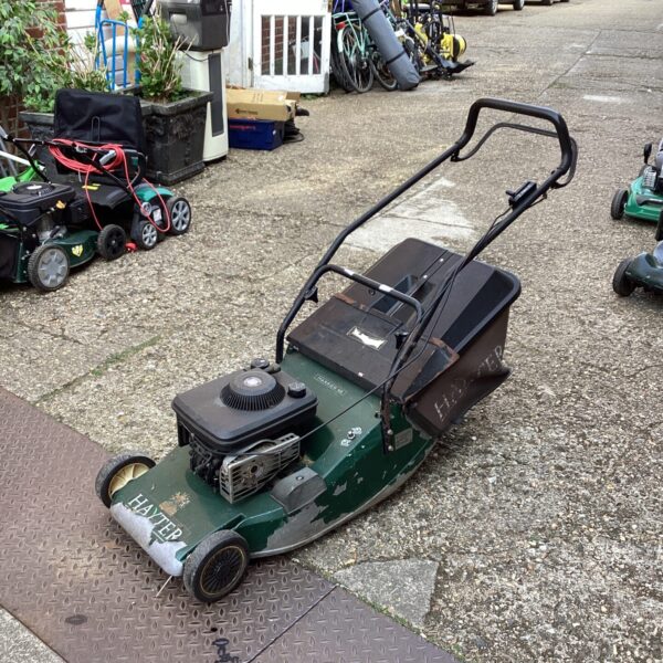 Vintage Hayter Harrier 48 petrol lawn mower in garden setting.
