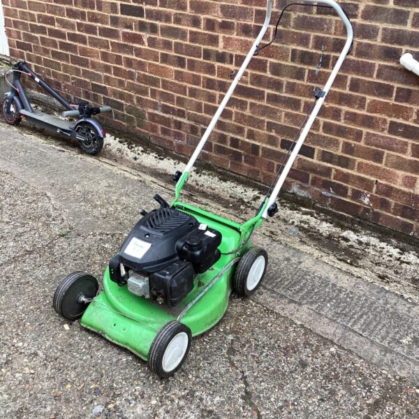 Green Viking petrol lawn mower in a garden setting.