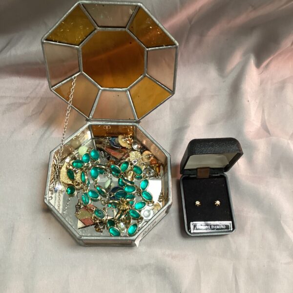 Vintage stained glass jewellery box filled with jewellery.