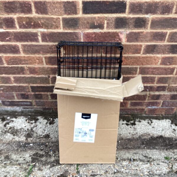 Metal greenhouse shelving unit in cardboard packaging.