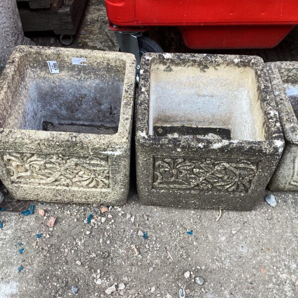 Pair of weathered stone effect garden planters for outdoor use.