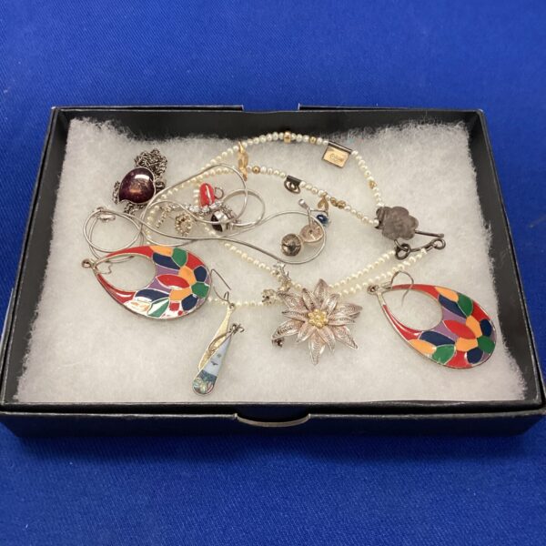 Vintage jewellery lot featuring silver brooches and pendants.