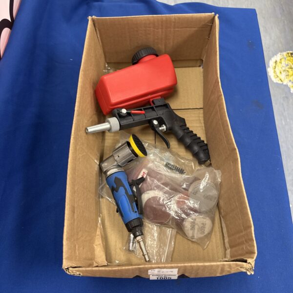 Unused pneumatic bodywork sander and spray gun for automotive repair.