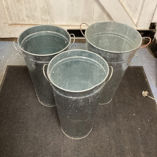 Three vintage galvanised buckets showing signs of age.