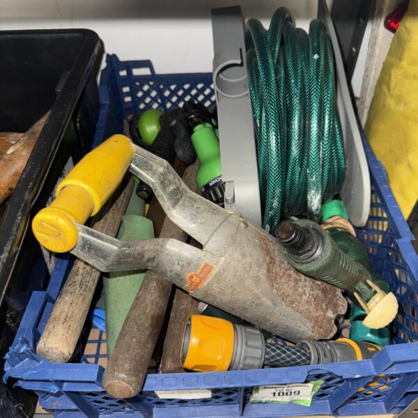 Assorted garden tools including a hose and hand tools.