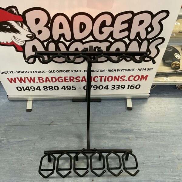 Metal gun rack displayed in front of Badgers Auctions signage.