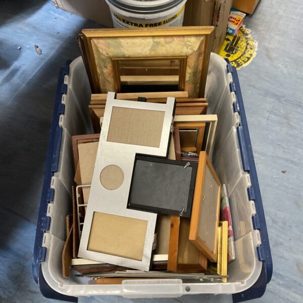 Assorted photo frames in a box, a large collection of picture frames.