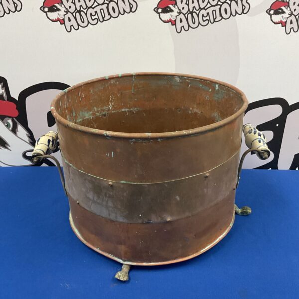 Antique copper bucket with blue and white porcelain handles.