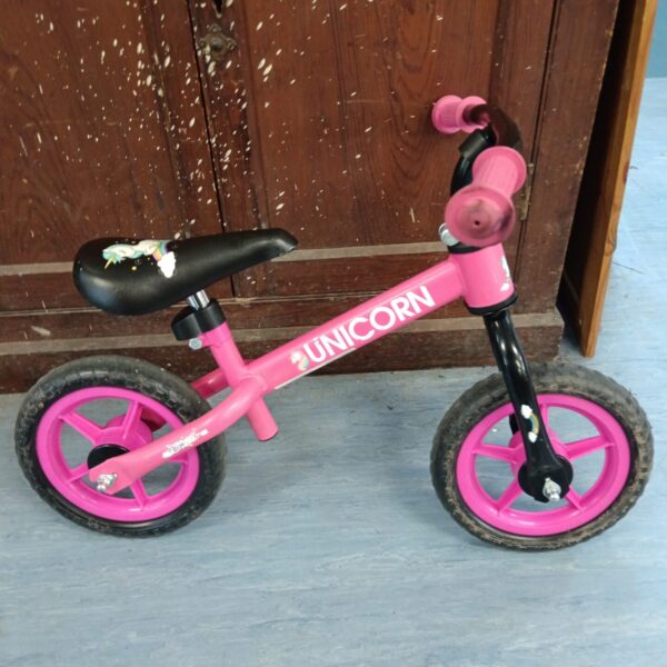 Pink unicorn child's balance bike for toddlers and young children.