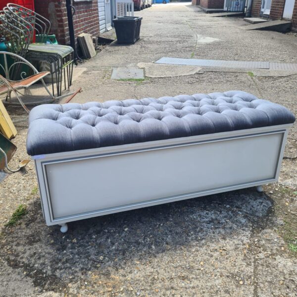 Front view of a 1970s button tufted ottoman.