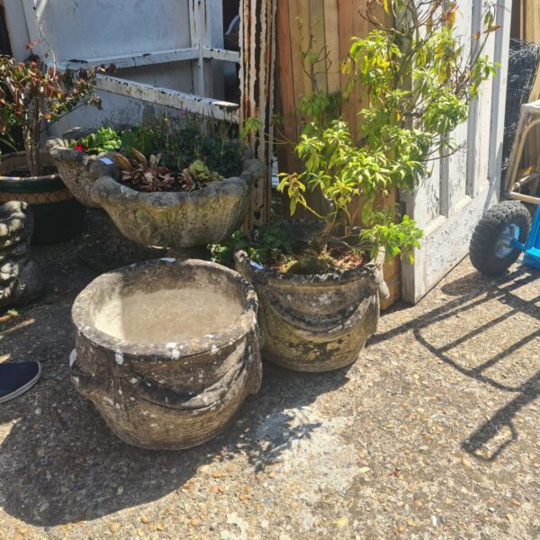 Weathered stone garden planters displaying a small plant.