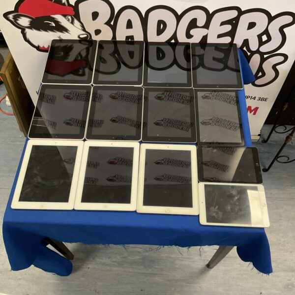 Blue table with a large lot of used Apple iPads.
