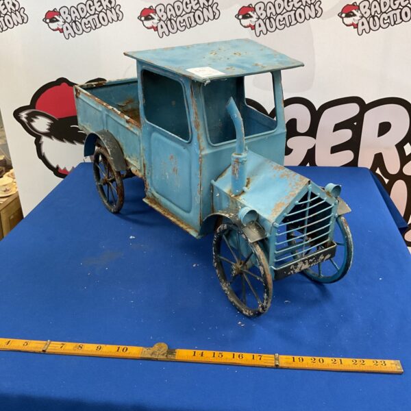 Vintage tinplate truck planter with weathered patina.