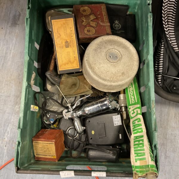 Mixed lot of military and collectible items in a wooden crate.