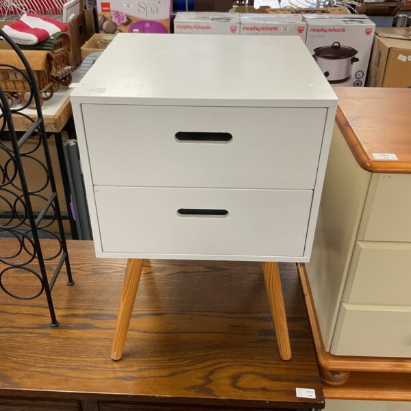 White two-drawer bedside table with tapered legs.
