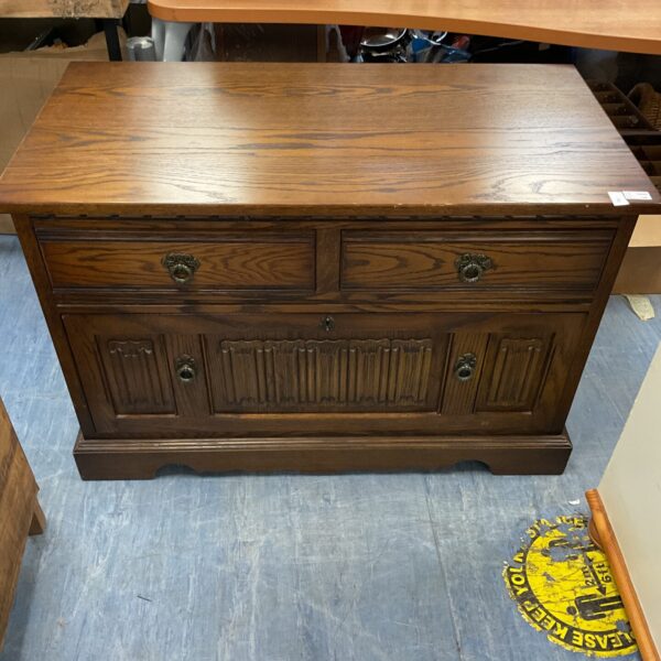 Vintage light oak filing cabinet with carved details.