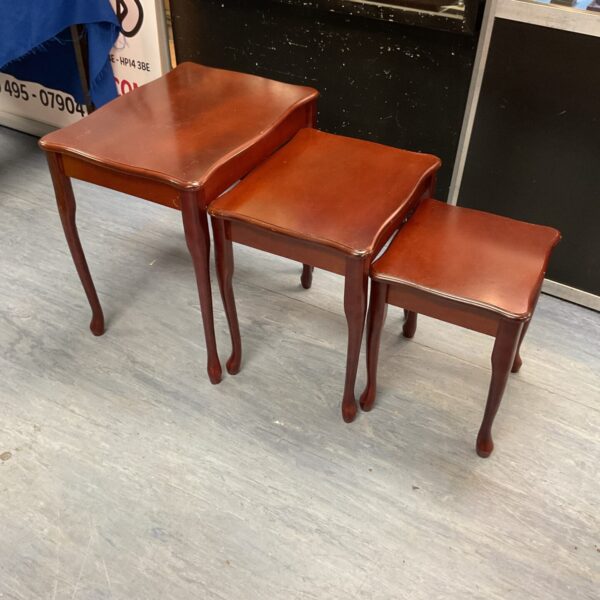 Vintage mahogany nest of tables in warm tones.