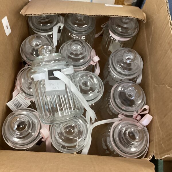 Vintage sweet jars with ribbon ties, a charming collectible display.