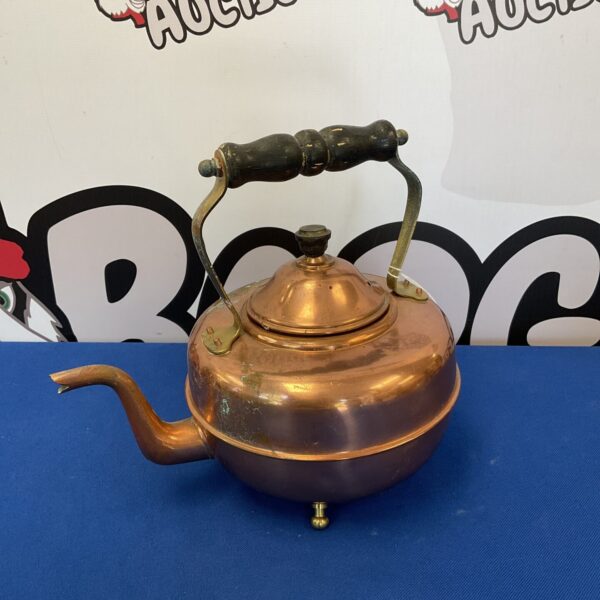 Vintage copper kettle with curved handle and spout.
