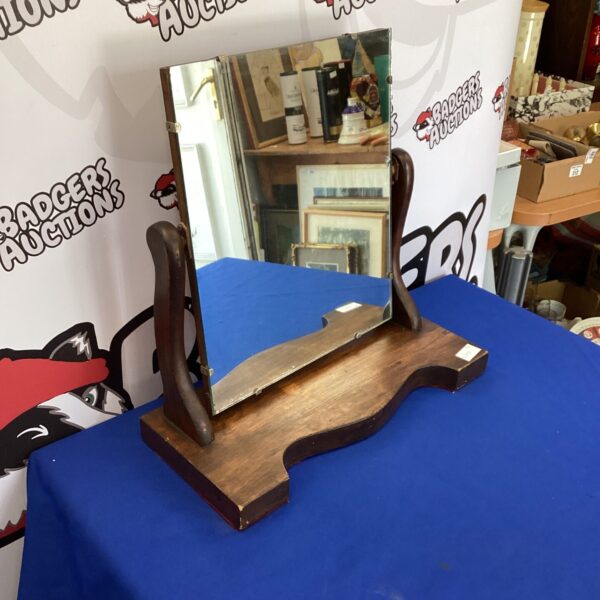Vintage dark oak dressing table mirror on a blue surface.