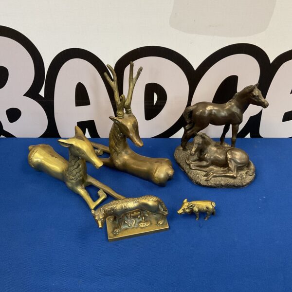 Vintage brass animal sculptures, including horse figurines, on display.