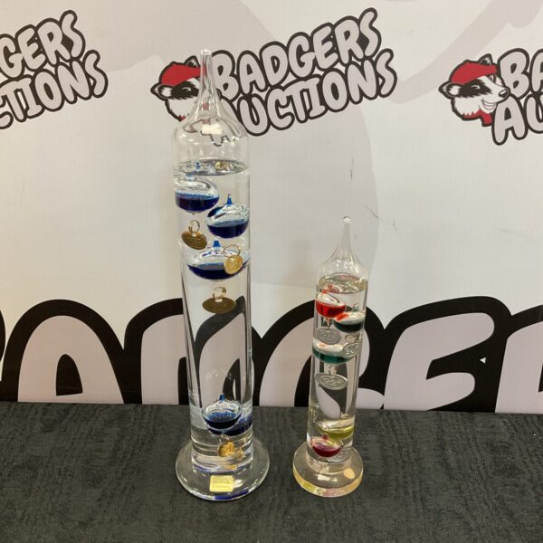 Pair of vintage glass Galileo thermometers displaying coloured bulbs.