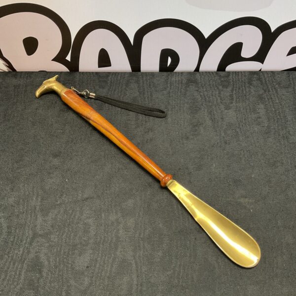 Antique brass shoe horn with phoenix head and wooden handle.