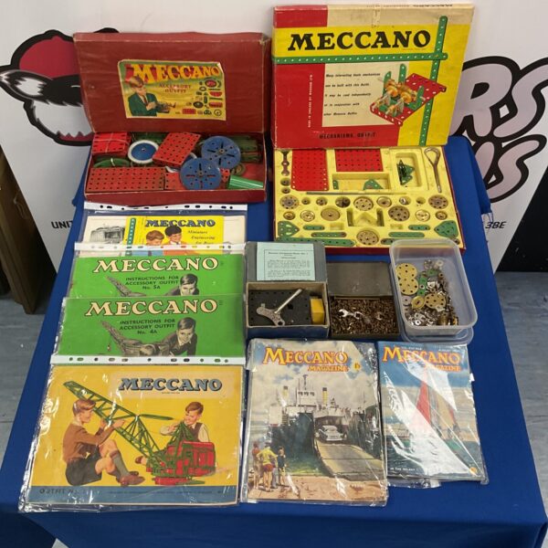 Vintage Meccano sets with manuals and a clockwork motor for collectors.