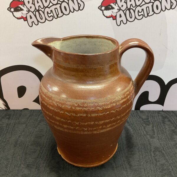 Large antique salt glazed pitcher with brown stoneware glaze.