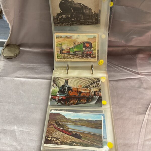 Vintage postcard album featuring steam locomotives and transport cards.