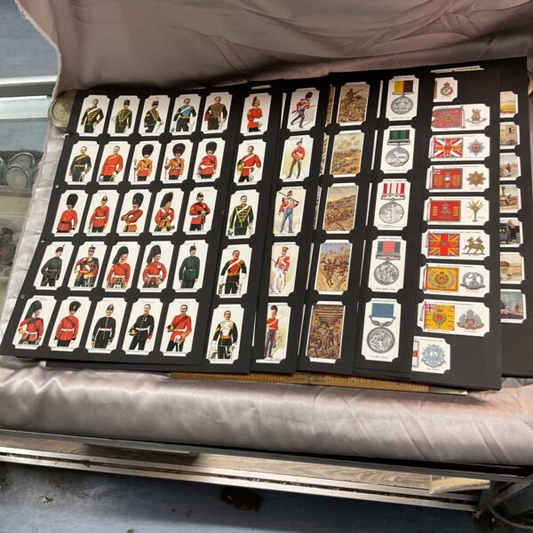 Large collection of vintage reproduction cigarette cards with military and transport themes.