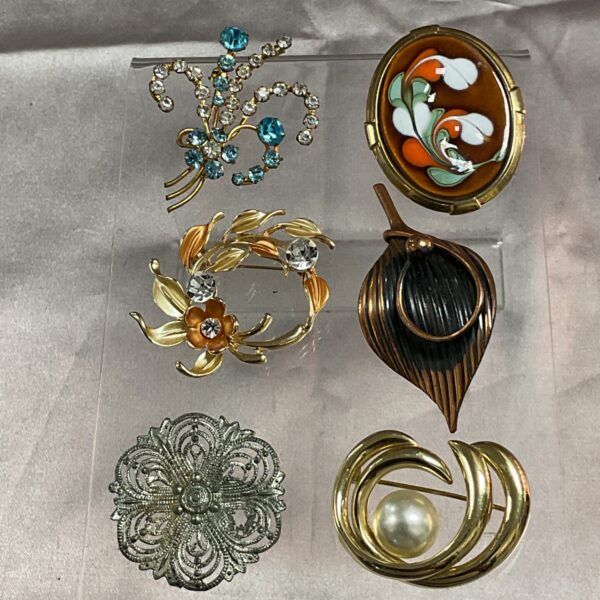 A lot of six vintage costume jewellery brooches with varied designs.