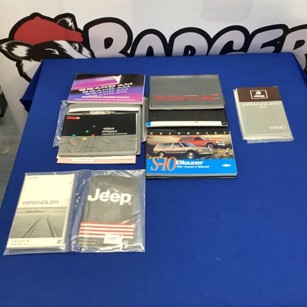 Vintage car owners manuals, including a 1989 Pontiac and Jeep.