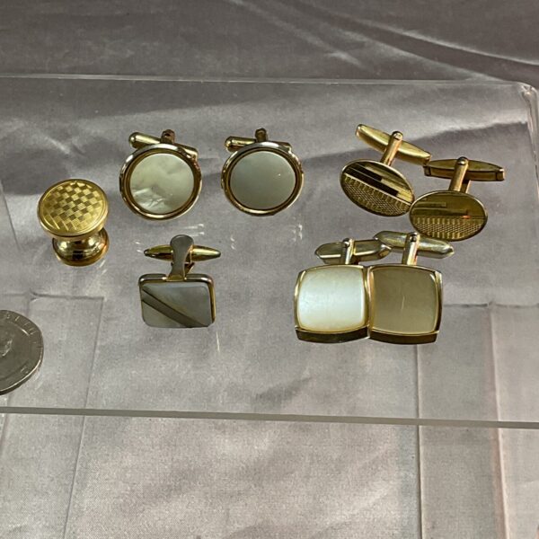 Vintage gold tone cufflinks displayed on a tray.