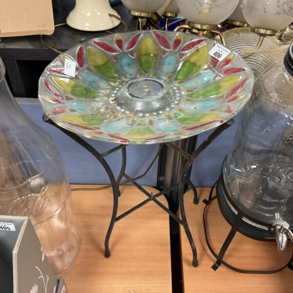 Colourful vintage glass bird bath on wrought iron stand.