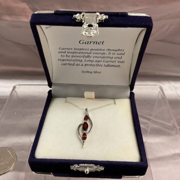 Vintage garnet pendant necklace in sterling silver, close-up view.