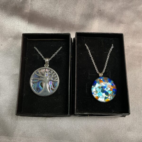 Iridescent abalone shell tree pendant on silver necklace.