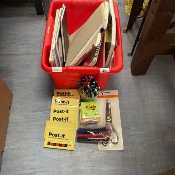 Red plastic box filled with office stationery and supplies.