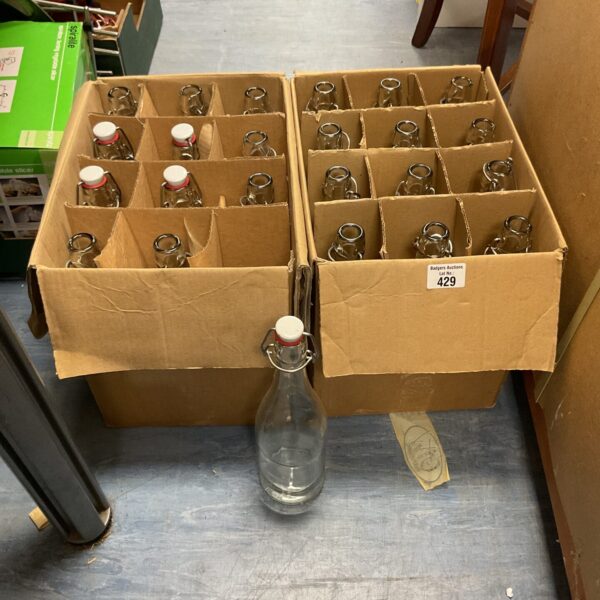 Lot of 24 clear glass bottles with swing tops for storage.