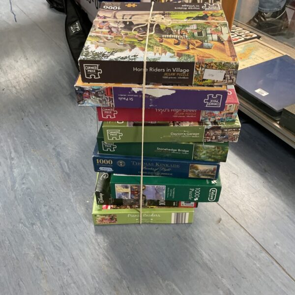 Mixed lot of jigsaw puzzles with corner piece included.