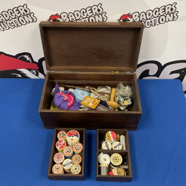 Vintage wooden sewing box filled with antique sewing notions.