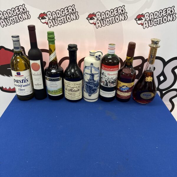 Vintage alcohol bottle collection featuring Pernod and Cognac.