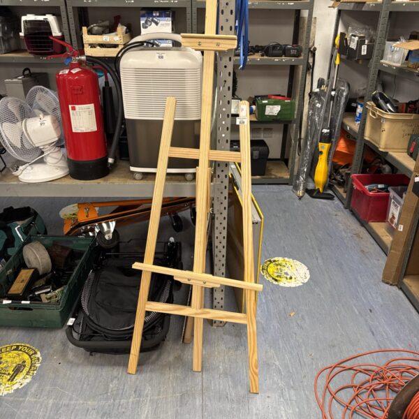 Large wooden artist easel in a studio setting.
