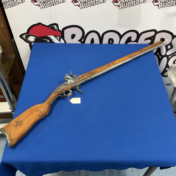 Antique flintlock musket rifle displayed on a blue background.