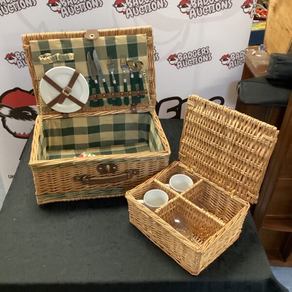 Vintage wicker picnic hamper with plates inside.