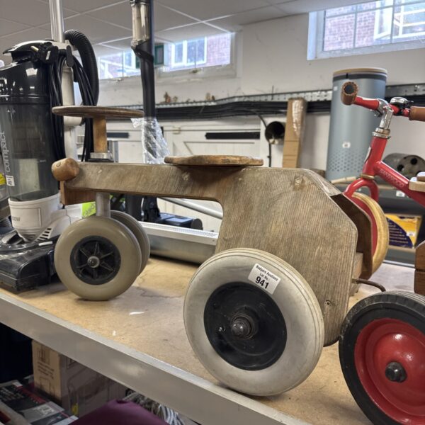 Vintage wooden ride on car with four wheels and weathered paint.