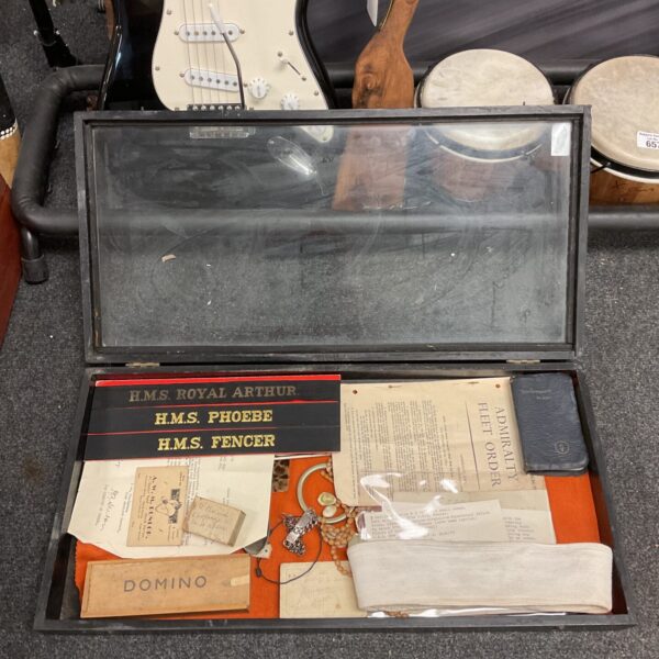 Vintage militaria display case with US Navy hat and pork pie hat.