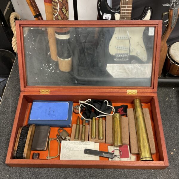 Vintage display case showcasing antique canon shells and military artifacts.