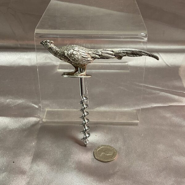 Antique silver pheasant corkscrew on a clear display stand.